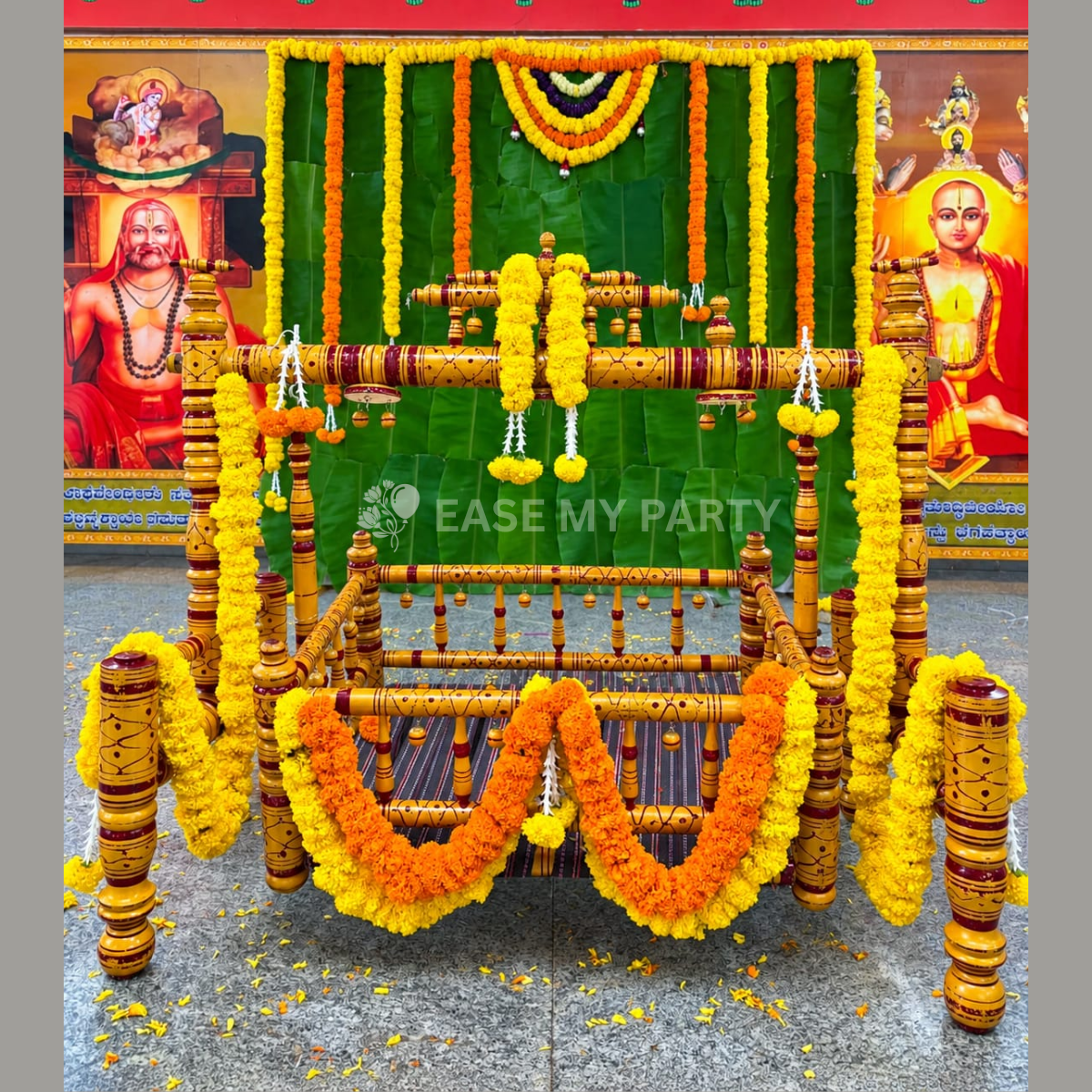 Traditional wooden cradle ceremony decoration with fresh marigold garlands and banana leaf backdrop in Bangalore by EaseMyParty