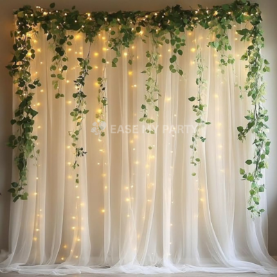 White galaxy netted backdrop with artificial green foliage vines, fairy lights, and rental cradle for naming ceremony in Bangalore by EaseMyParty